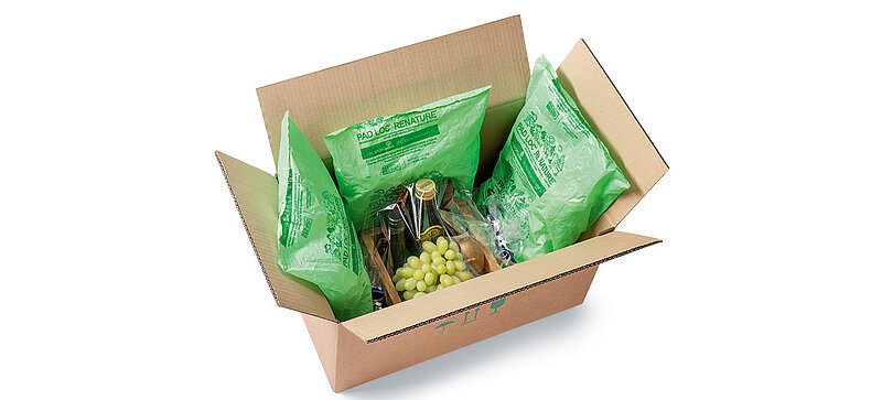 A box containing a present padded with plastic bags with packing chips