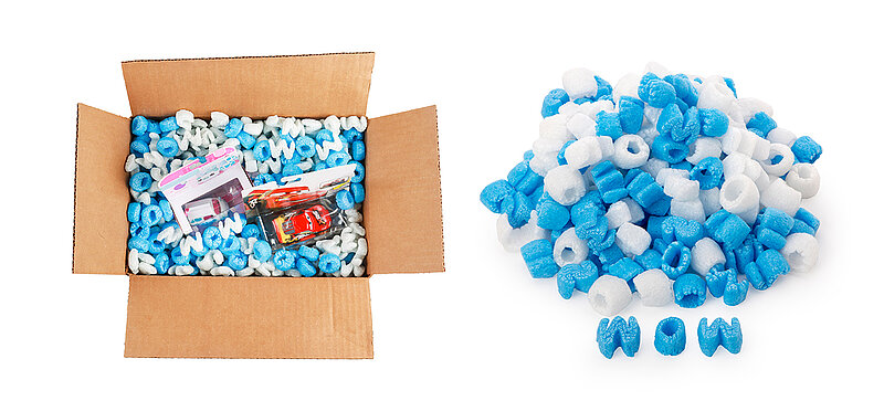 Ein Karton mit Kinderspielzeug und blauen und weißen Verpackungschips in Buchstabenform