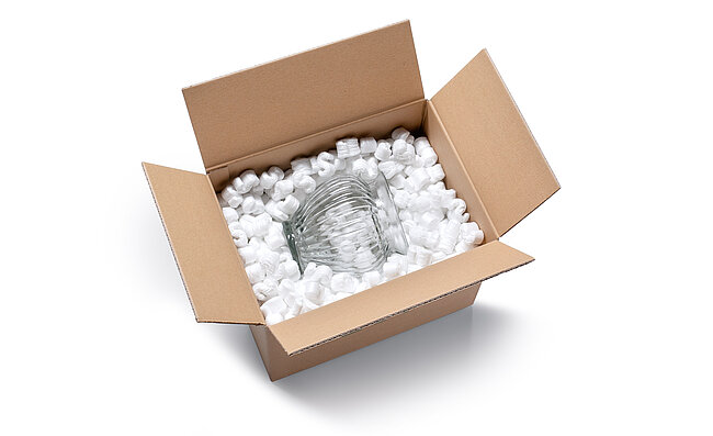 Ein Karton mit einer Glas Vase und weißen S-förmigen Verpackungschips