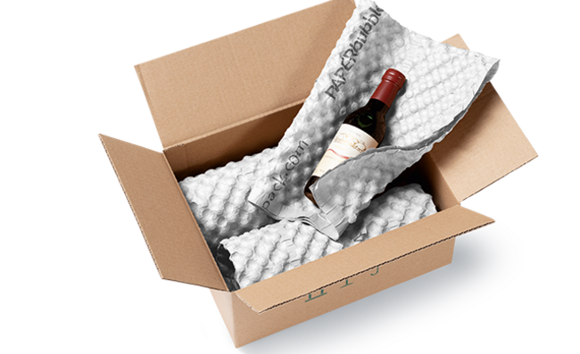 Ein Karton mit Weinflaschen, die in weiße Papierpolsterbögen eingewickelt sind