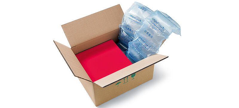 Ein Karton mit einer roten Box und Recycle Luftpolstern